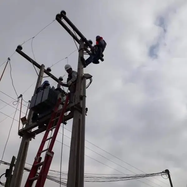 Cuadrilla de GES Ingeniería montando equipos sobre una estructura de media tensión